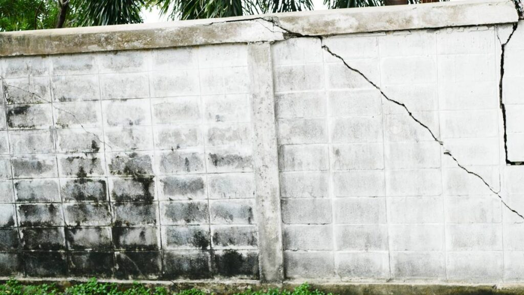 a white retaining wall with a big crack across - Fixing or replacing your retaining wall